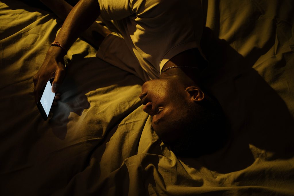 scrolling phone at night lying in bed