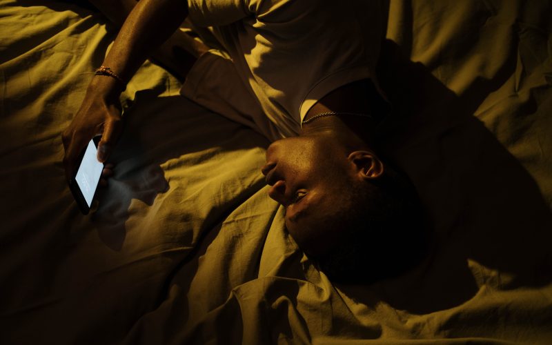 scrolling phone at night lying in bed